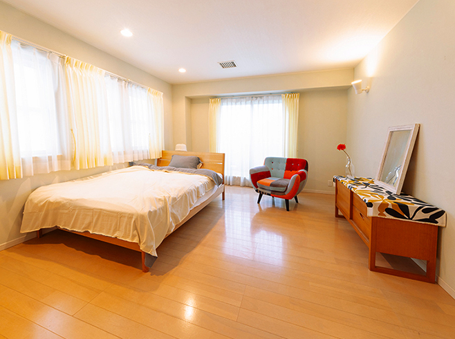ベッド、チェア、チェストなどを配した寝室インテリアの一例写真